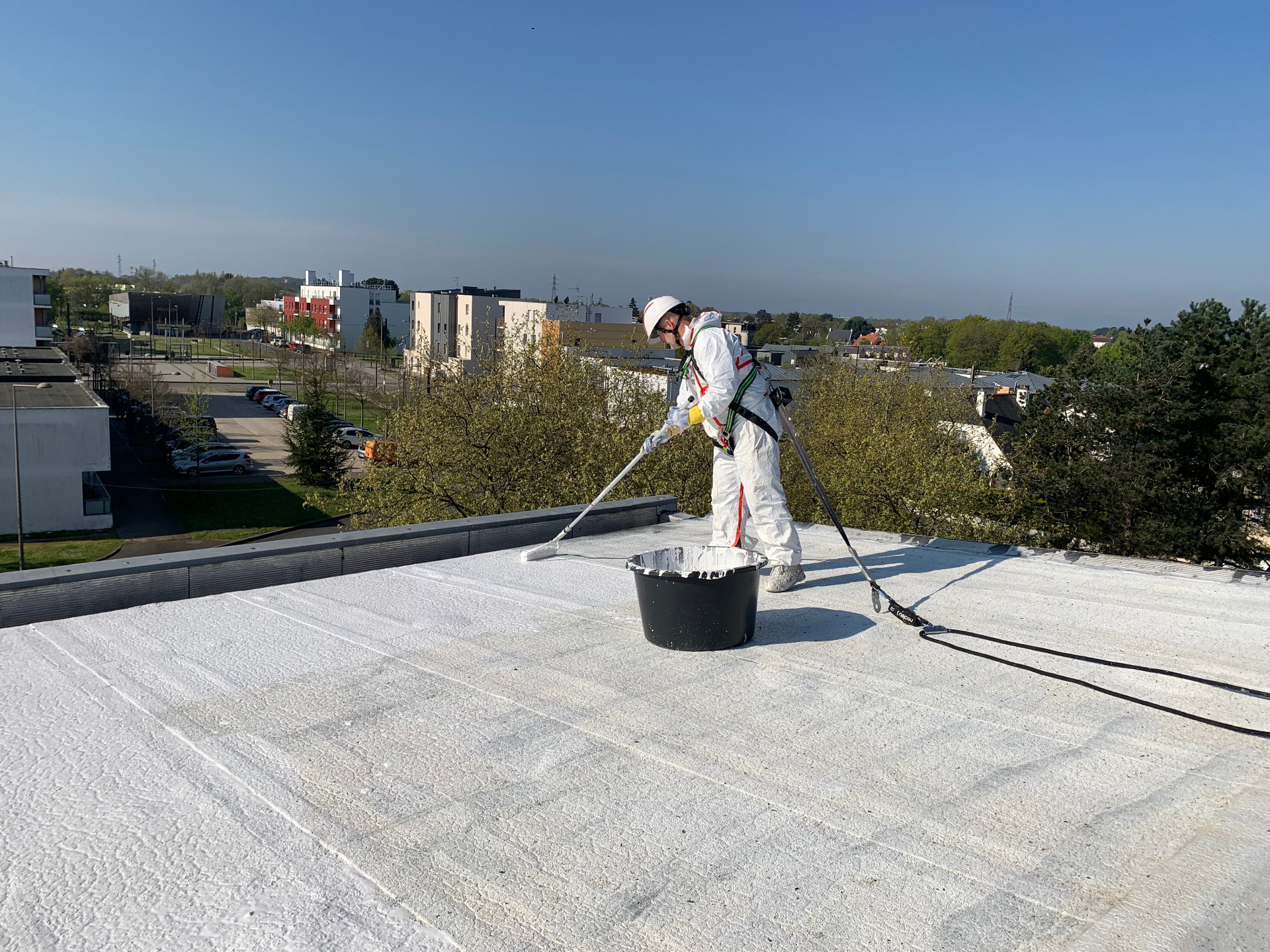 Application du revêtement Cool Roof au rouleau par un couvreur équipé