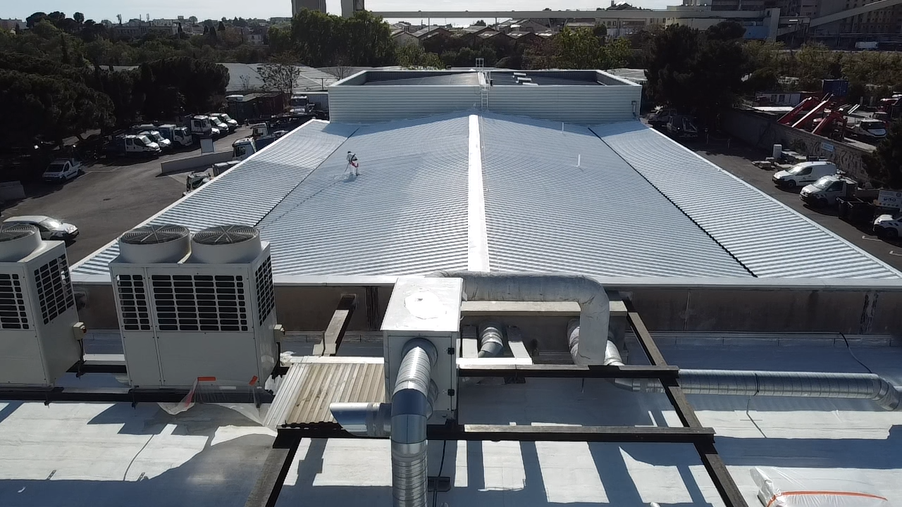 Chantier professionnel sur toiture bac acier traitée Cool Roof
